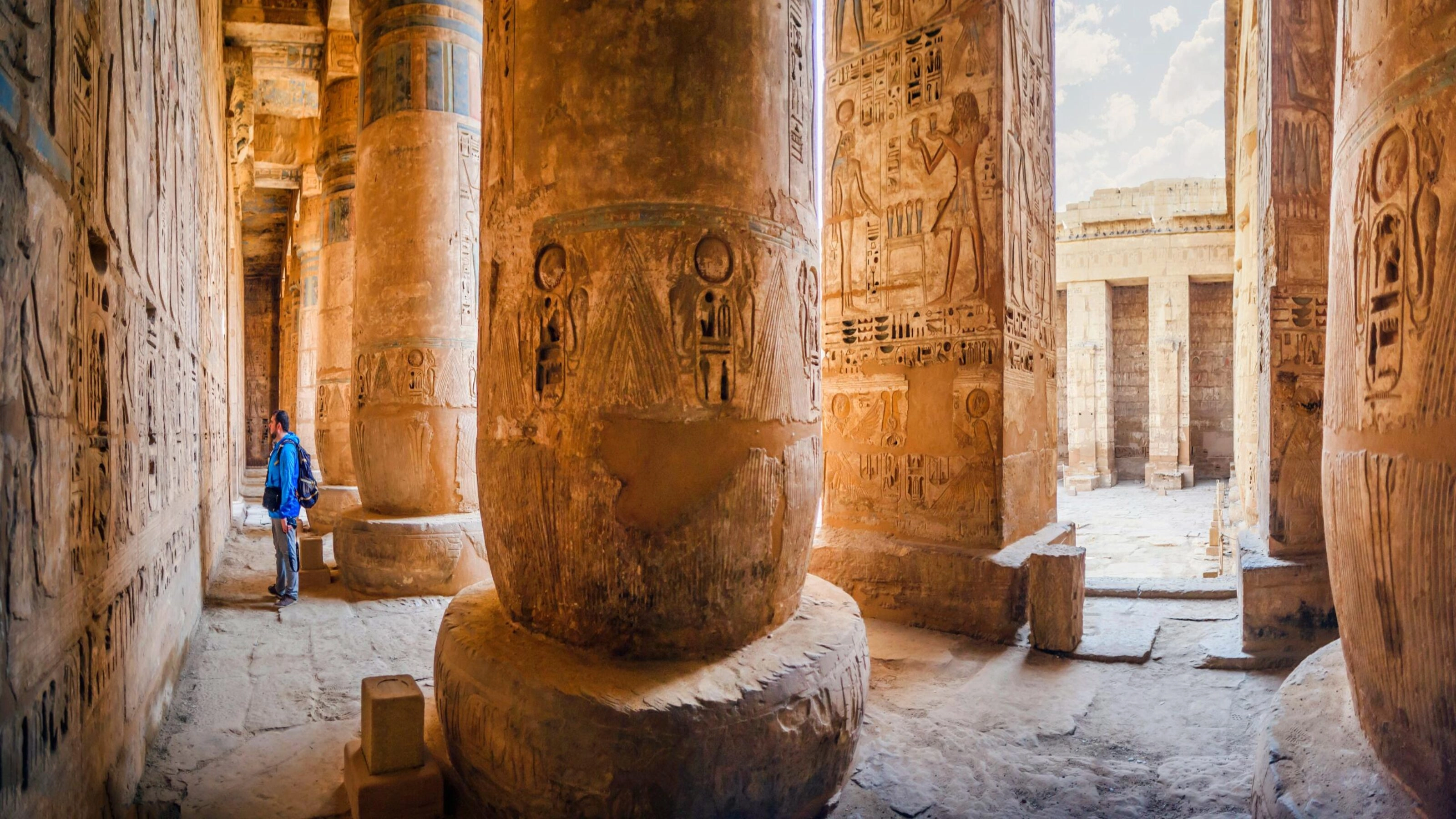 Luxury Egypt Tours - A tourist examines the hieroglyphs on the walls of the temple of Medinet Habu, Luxor, Egypt