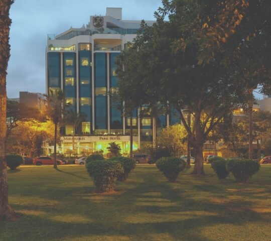 External view of the front of the Belmond Miraflores Park Hotel (Lime, Peru) at twilight, taken from the surrounding parkland