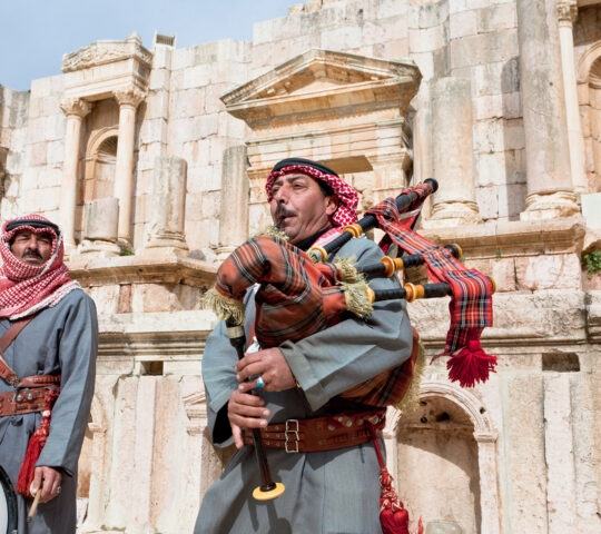 Bedouin plays on bagpipes in ancient town Gerasa (Jerash) in Jordan