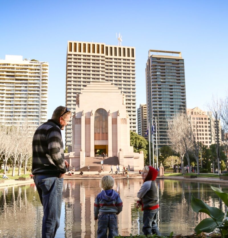 Rear view of family walking together on the beach with the Gold Coast city skyline in the background