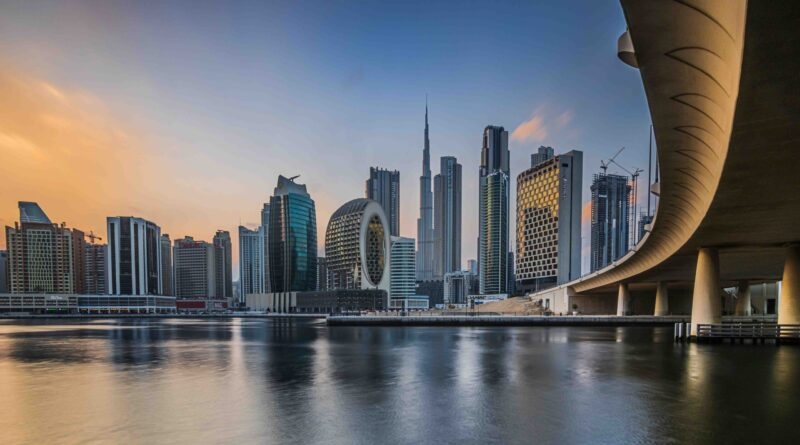 Dubai skyline at sunset featuring the Burj Khalifa and a curved bridge for luxury United Arab Emirates tours.