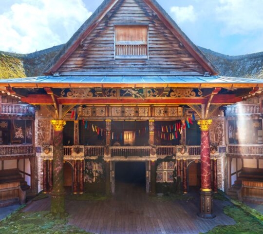 The ornate wooden stage and galleries of a reconstructed Elizabethan theater.