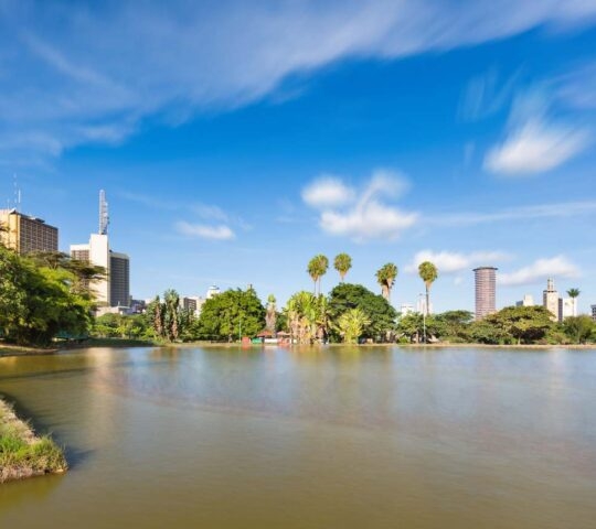 Long exposure of the skyline of Nairobi, Kenya with the beautiful lake in Uhuru Park in the foreground and some blurred boats.