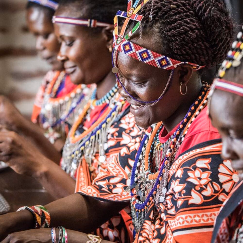 Women in traditional dress creating beadwork on a Great Migration luxury safari