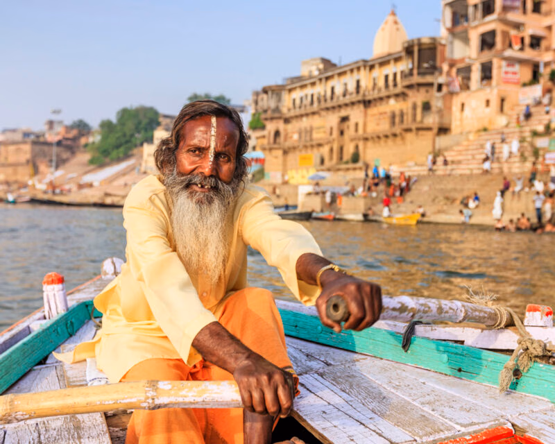 Sadhu rowing boat on the holy Ganges River in Varanasi