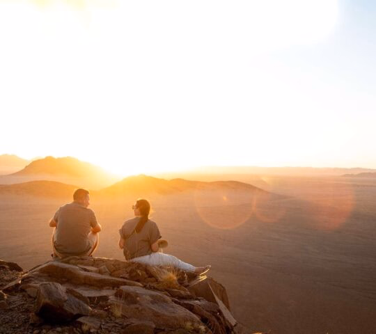 Two people enjoying the views over the Namib Desert at sunset