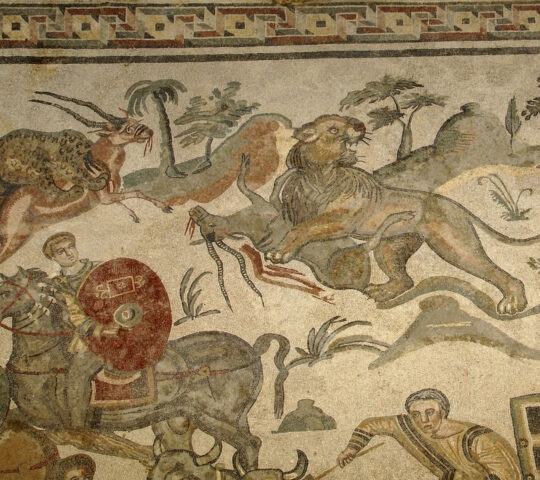Ancient Roman mosaic showing a horseman and a lion hunting animals in a landscape with trees.
