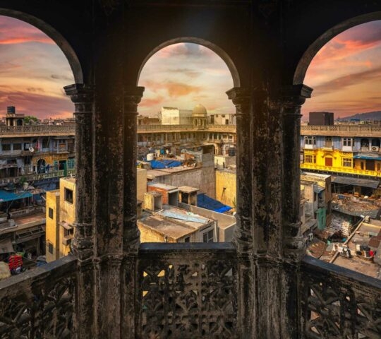 View through stone archways of a busy square in Old Delhi