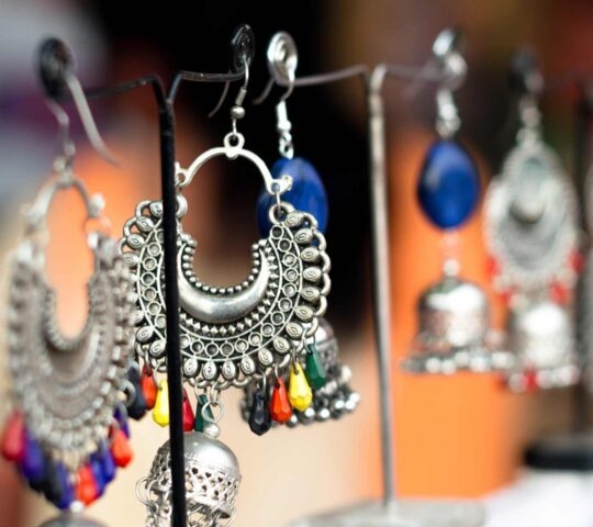 Silver and beaded earrings hanging on small stands