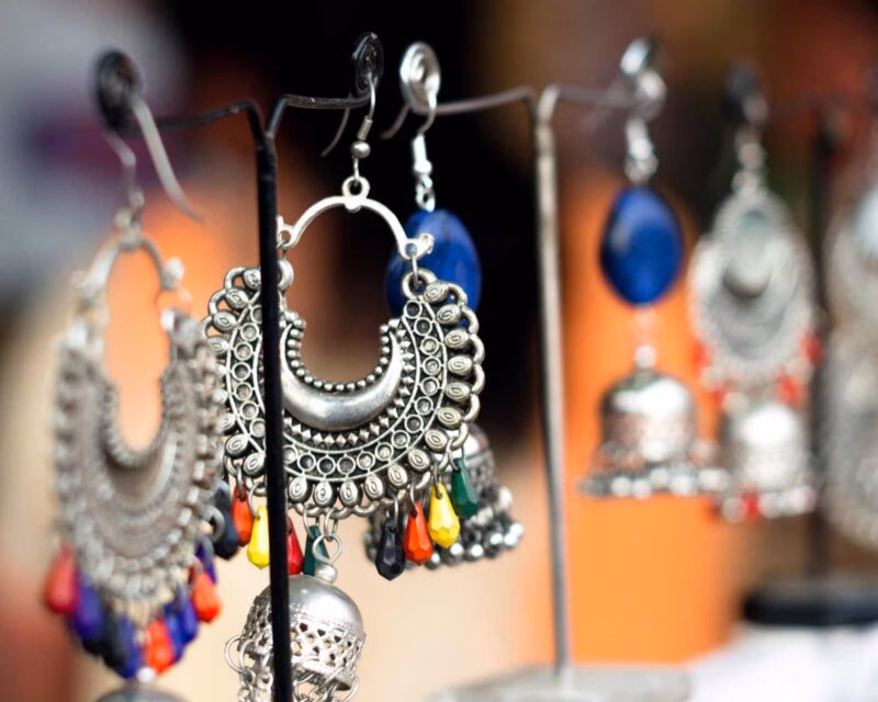 Silver and beaded earrings hanging on small stands