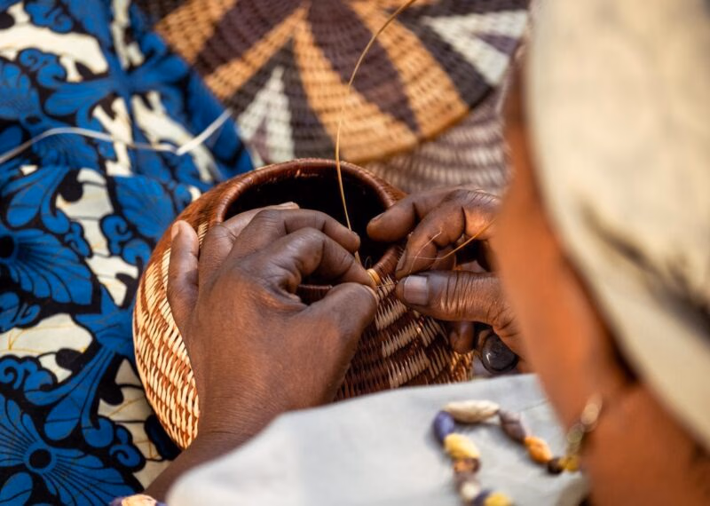 Local constructing a woven basket in Botswana