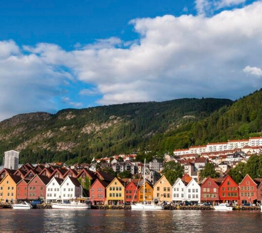 Colourful houses or Bergen, Norway, and moored sailing boats lining the water's edge