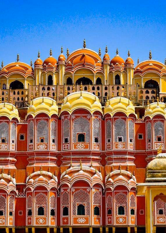 Close-up of the ornate, multi-story red and yellow sandstone facade of Hawa Mahal with its distinct honeycombed windows.