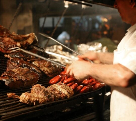 Argentinian chef cooking meat on a grill