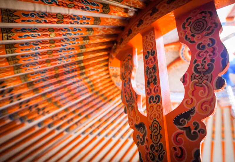 Painted orange wooden roof structure inside a yurt, a cultural feature of luxury Mongolia holidays.