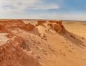 Wide view of red sandstone cliffs and desert plains, a landscape highlight of luxury Mongolia tours.
