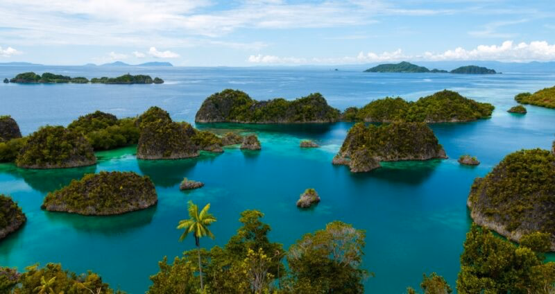 Scenic view of green karst islands in turquoise ocean water during luxury Asia grand tour vacations.