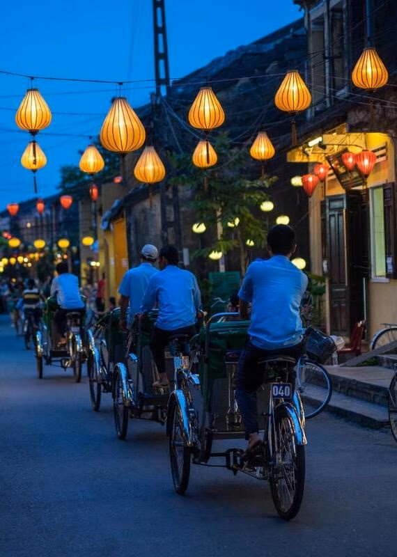 Cyclists on a street light by lanterns in Hoi An, Vietnam