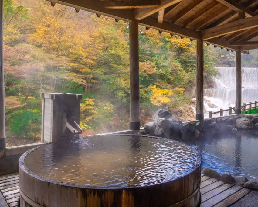 Japanese Hot Springs Onsen Natural Bath Surrounded by red-yellow leaves. In fall leaves fall in Fukushima, Japan.