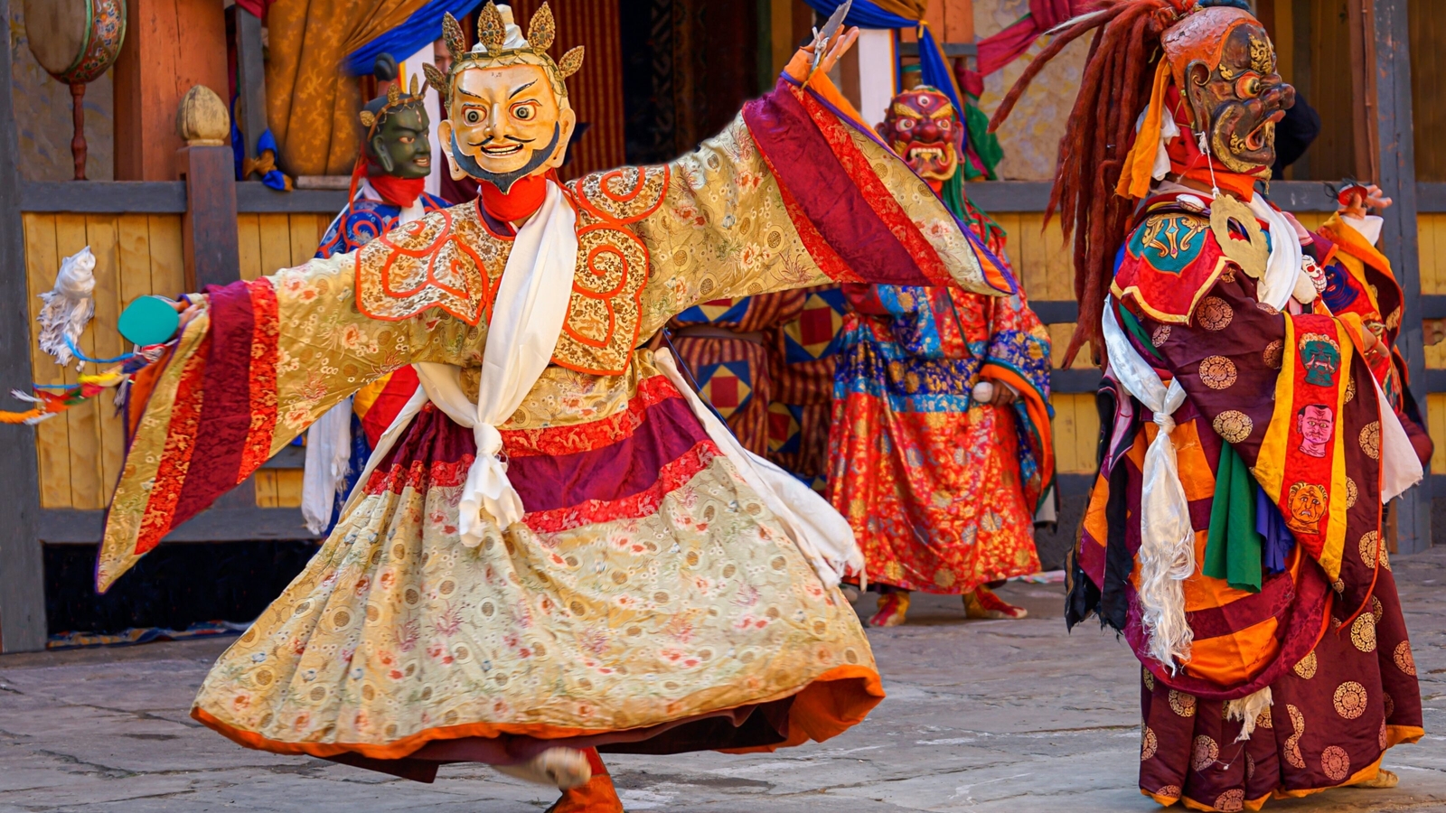 Performers in vivid traditional costumes dancing at a cultural festival.