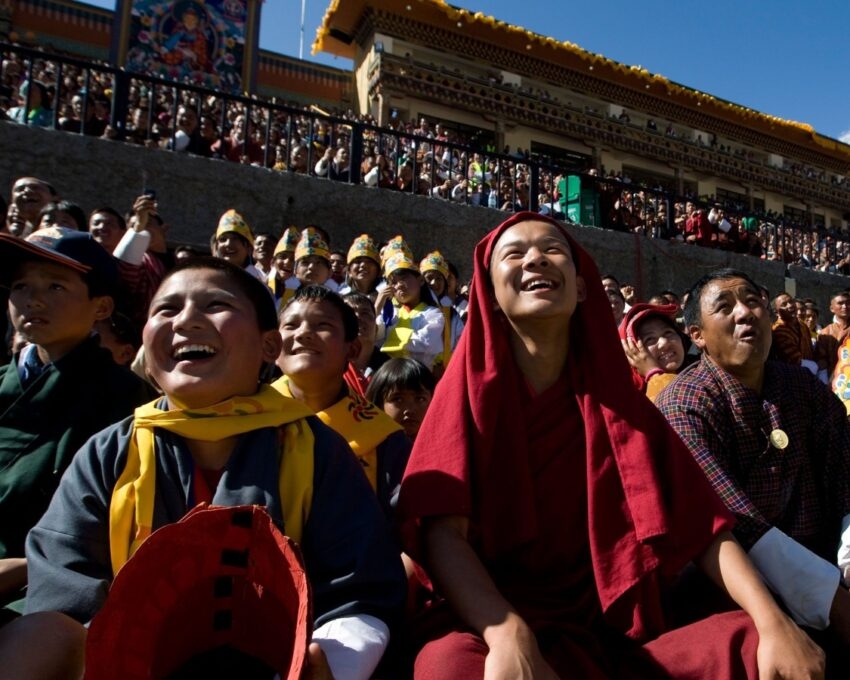Crowd at an outdoor event with people dressed in traditional and religious attire.