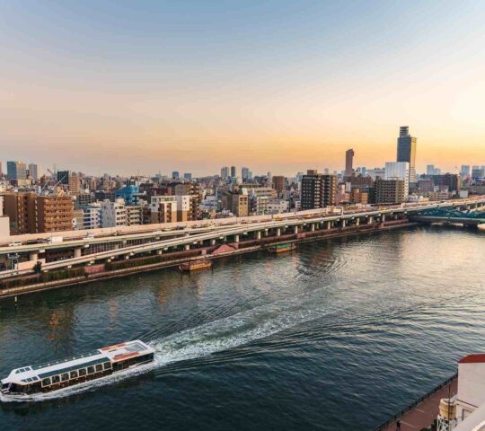 Sumida river with a cruise ship at sunset in Asakusa district Tokyo city, Japan.