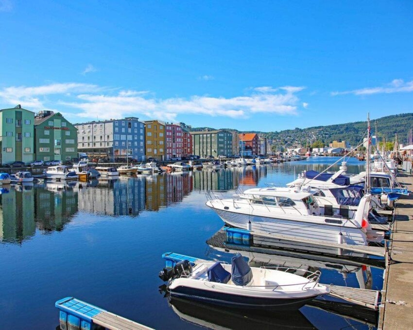 Colorful buildings by a marina with boats on clear day.