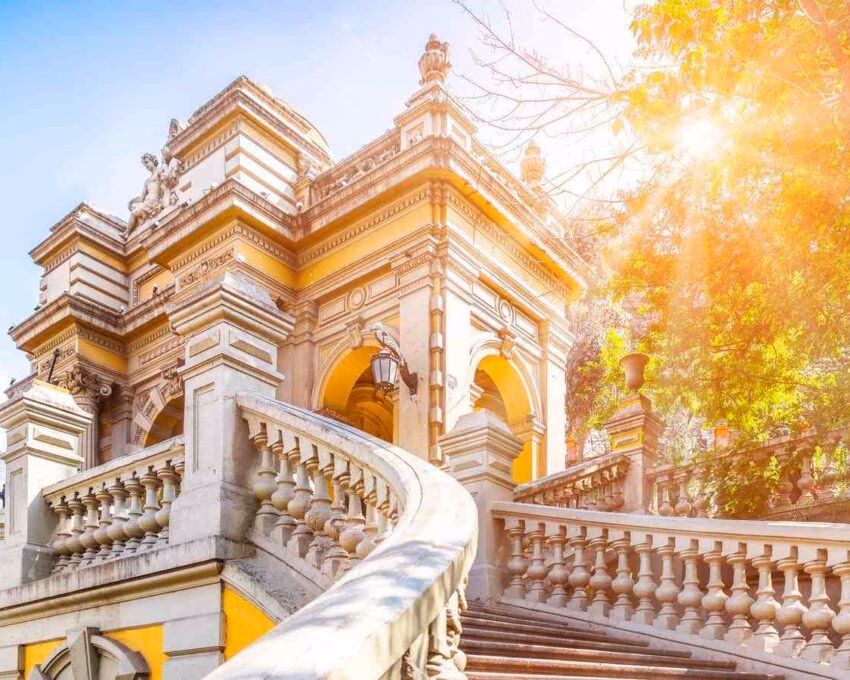 Elegant baroque staircase and ornate building facade bathed in warm sunlight.