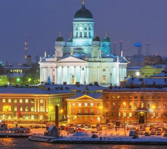 A snowy evening view of Helsinki Cathedral illuminated against a twilight sky.