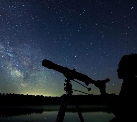 Woman with telescope watching the stars