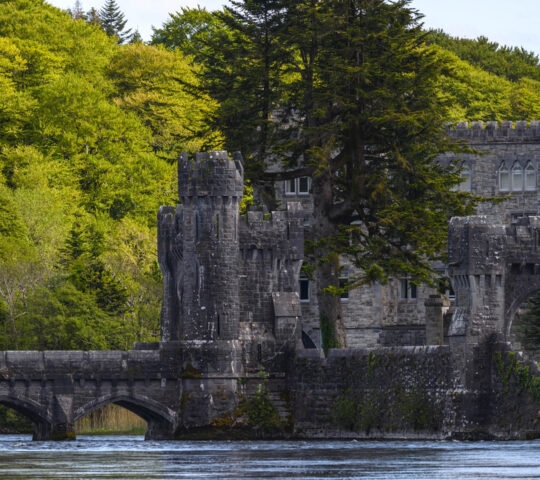 Ashford castle with stone bridge, river and forest