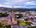Aerial view over the town of Letterkenny in Ireland in the evening - The urban landscape during sunset showcases vibrant, colorful buildings against a backdrop of a dramatic sky