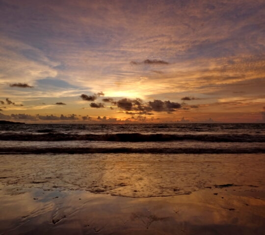 the beauty of Jimbaran beach in Bali Indonesia at dusk with the sun disappearing