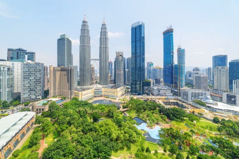 Aerial view of the KLCC Park and the Petronas Twin Towers in Kuala Lumpur, Malaysia. The urban park in Kuala Lumpur City Center is a popular tourist attraction of Asia. Awesome Kuala Lumpur skyline.