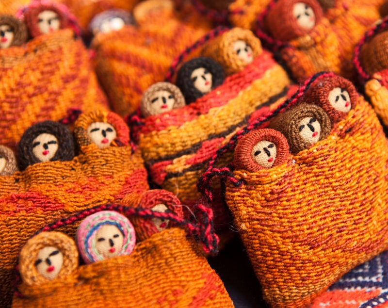 Colorful woven fabric dolls on display.