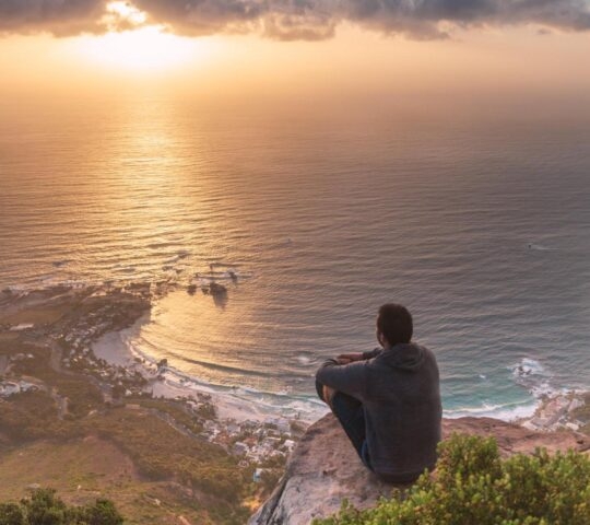 A man sitting at a viewpoint on the Lion's Head hike in Cape Town
