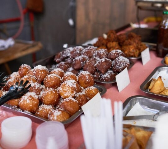 Balls of koeksisters dusted in coconut are for sale at a South African market
