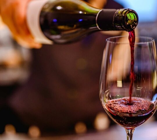 Pouring glass of red wine for a wine tasting