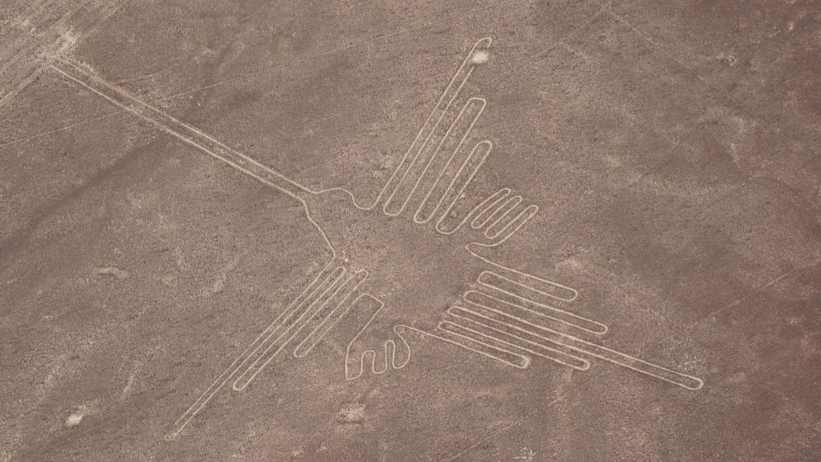 Aerial view of the Nazca Lines depicting a hummingbird geoglyph in Peru.
