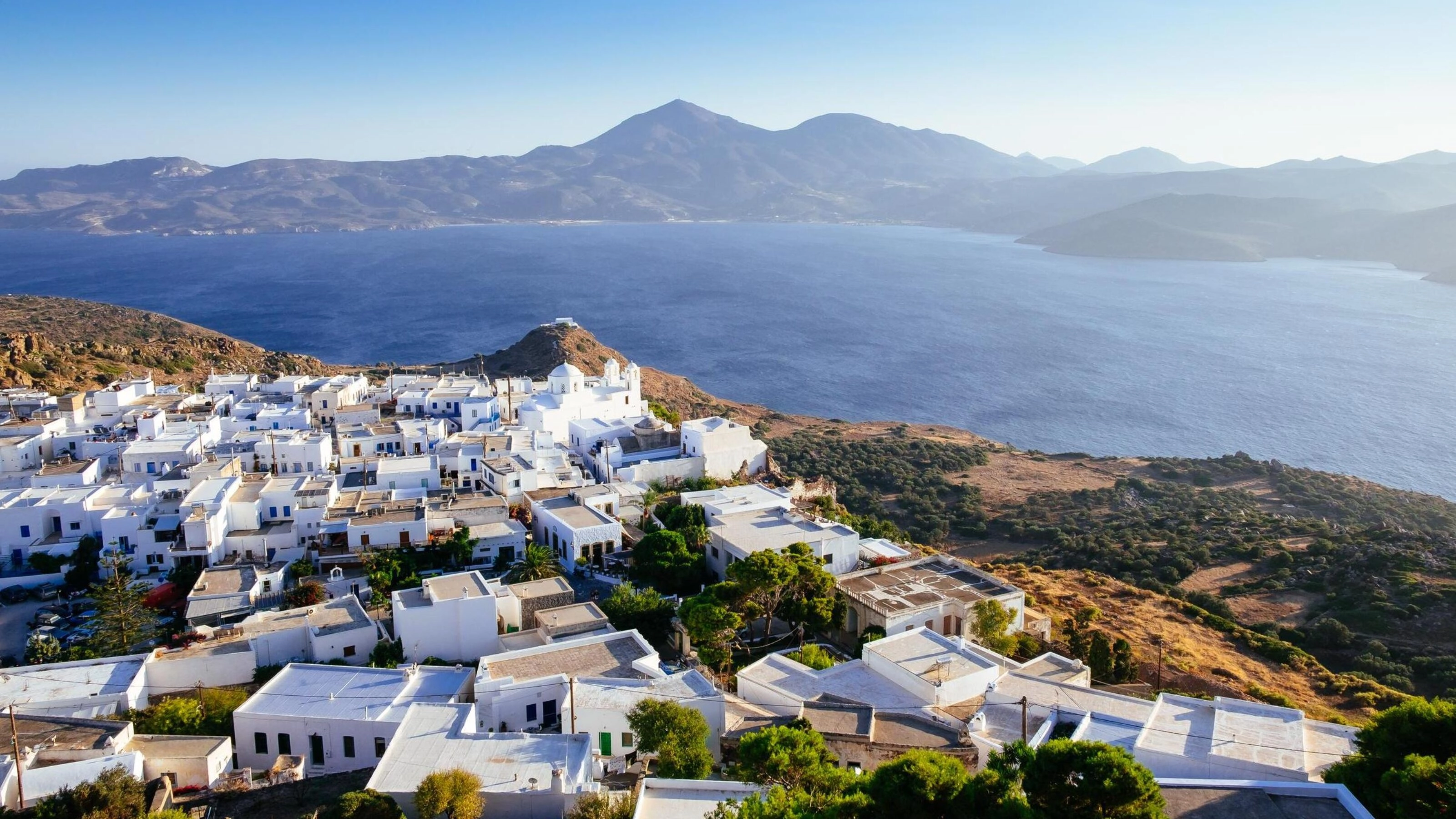 Aerial view of the ocean and white houses in Milos, Greece