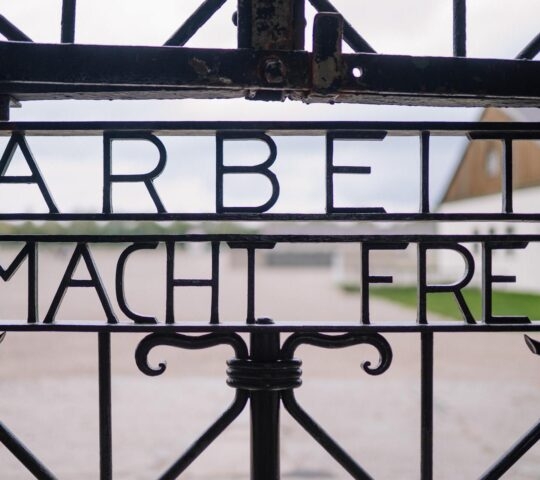 Iron gate with the inscription "ARBEIT MACHT FREI" at a historical site.