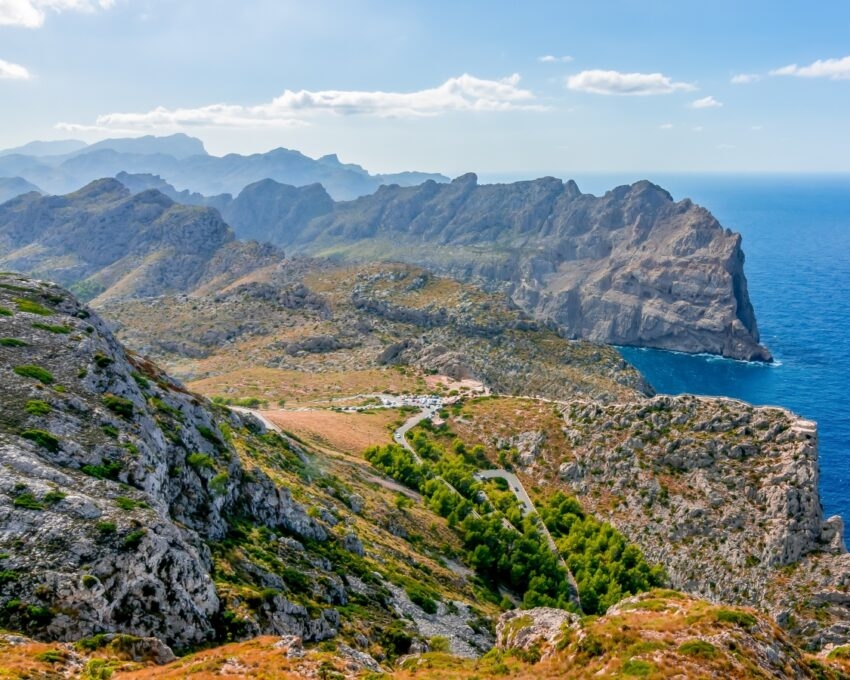 Scenic view of rocky coastal mountains and deep blue sea under a clear sky.