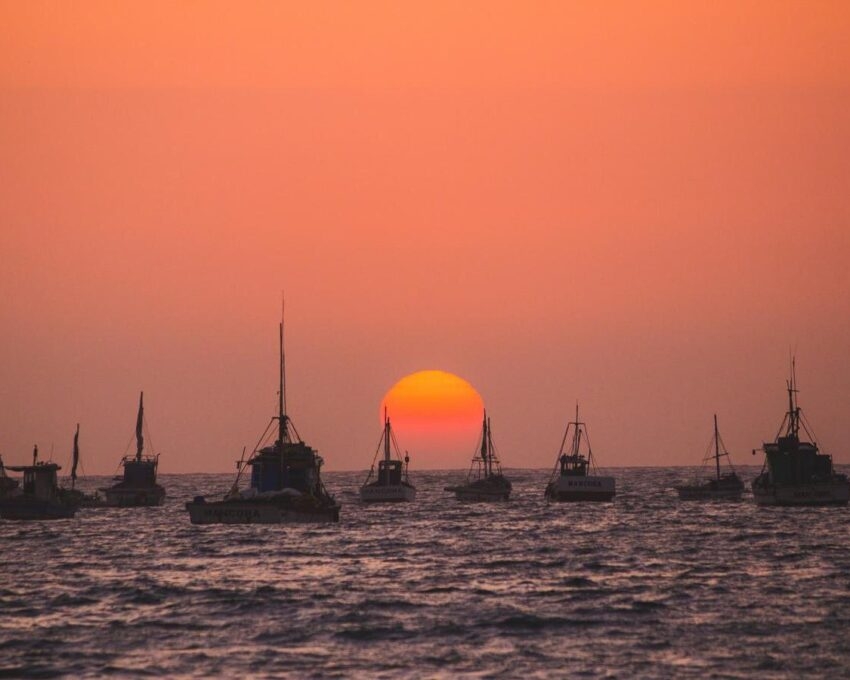 Fishing boats on the water at sunset in Mancora, Peru