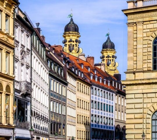 European street view with colourful historic buildings and ornate towers in the background.