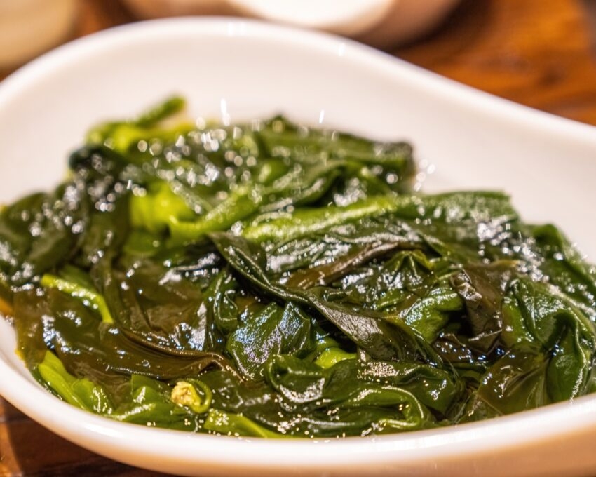 A dish of kelp with a glossy appearance served in a white bowl.