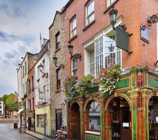 Picturesque street with historic buildings and a pub with floral decoration.