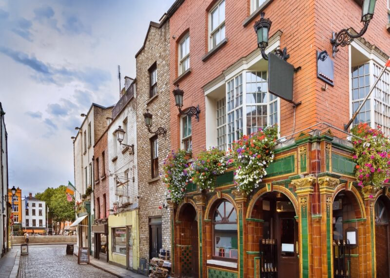 Picturesque street with historic buildings and a pub with floral decoration.