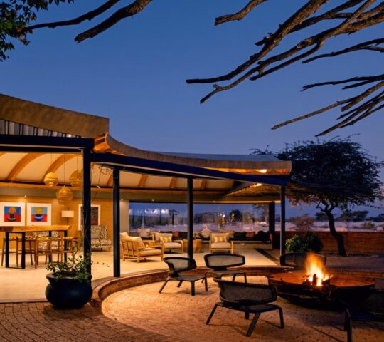 Luxury outdoor patio with a fire pit at twilight, overlooking a serene landscape.