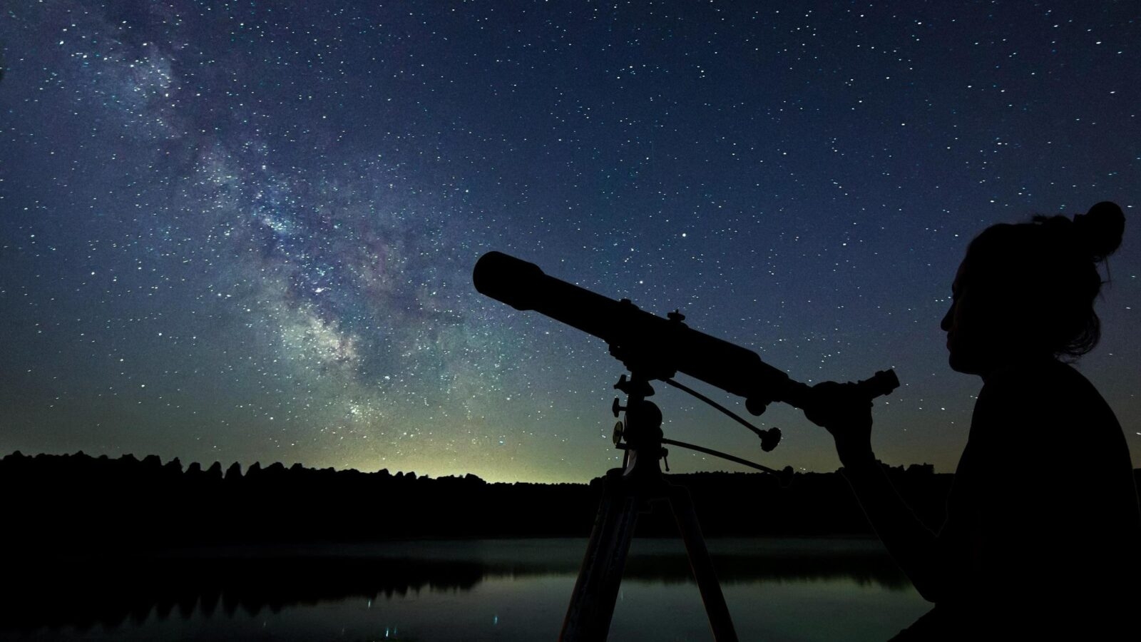 Woman with telescope watching the stars.