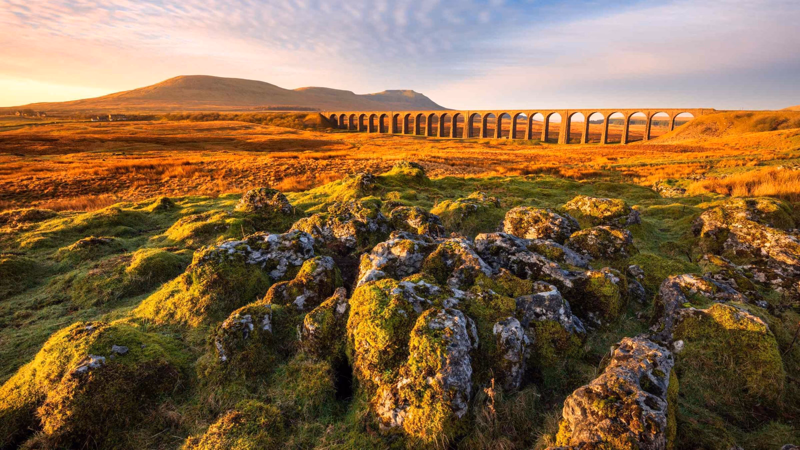 Beautiful scenic view with golden morning light at Ribblehead Viaduct in The Yorkshire Dales National Park, UK.
